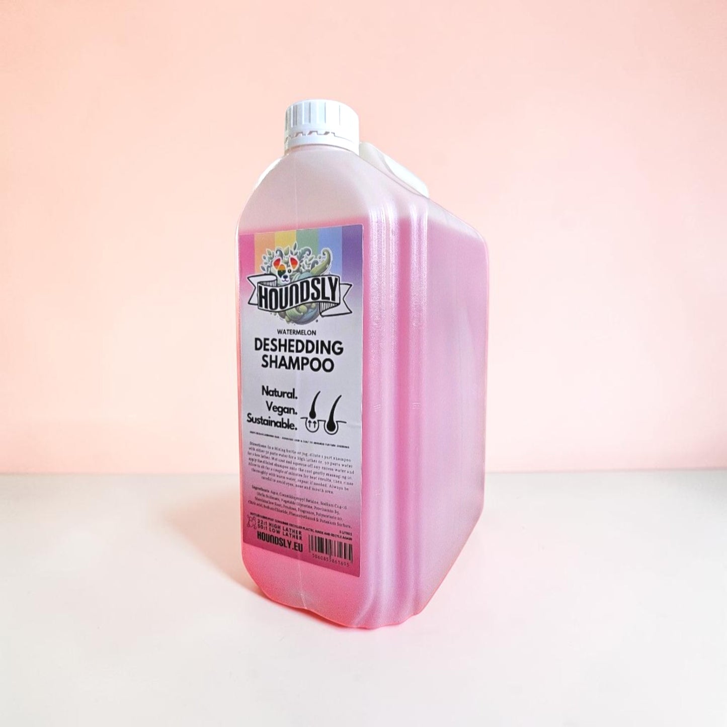 Houndsly Watermelon Deshedding Dog Shampoo, a large pink bottle with a rainbow label. Natural, Vegan, Sustainable.