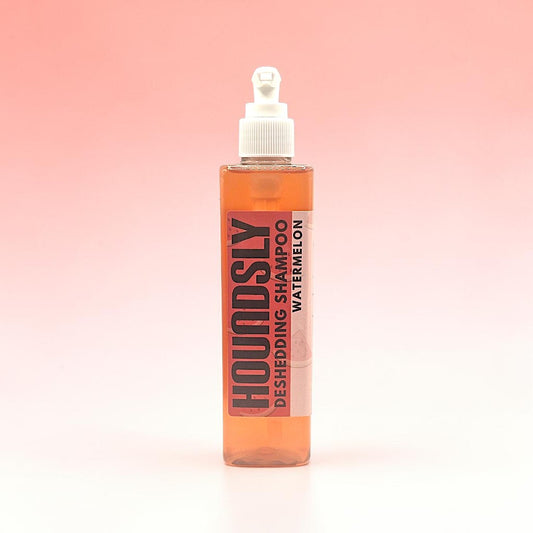 Houndsly Deshedding Dog Shampoo in Watermelon scent, a clear orange liquid in a pump bottle.