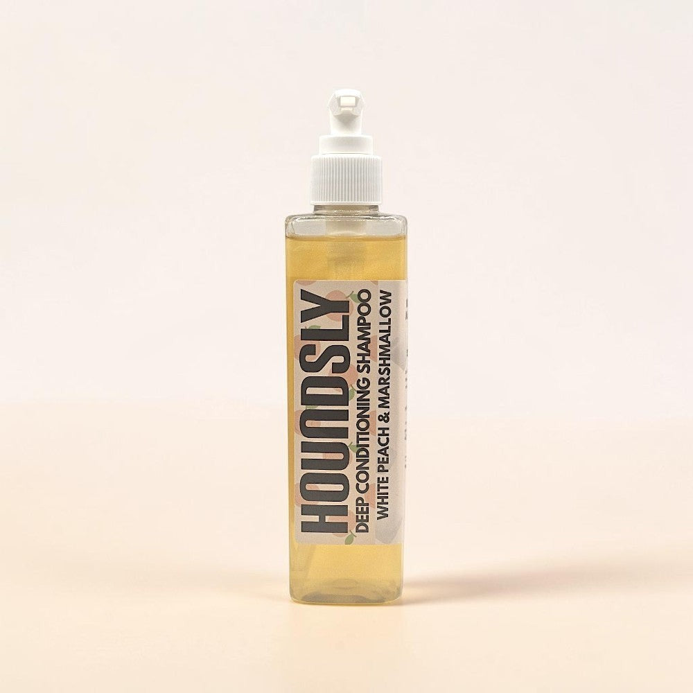 Houndsly Deep Conditioning Dog Shampoo in White Peach & Marshmallow scent. Clear, pale yellow liquid in a clear pump bottle.