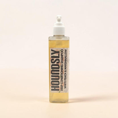 Houndsly Deep Conditioning Dog Shampoo in White Peach & Marshmallow scent. Clear, pale yellow liquid in a clear pump bottle.