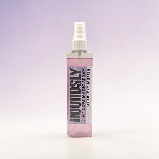 Frente Perfumada Ltd, T/A Houndsly EU Pet Products 5 in 1 Coat Magic Spray in Blueberry Muffin scent. Clear bottle with pink liquid and purple label.